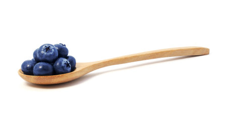Blueberries in wooden spoon isolated on white backgroundの写真素材