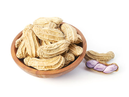 Boiled peanuts in wooden bowl isolated on white backgroundの写真素材