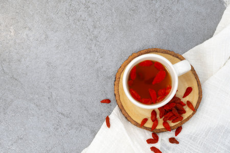 Cup of tea with goji berries on stone texture backgroundの写真素材