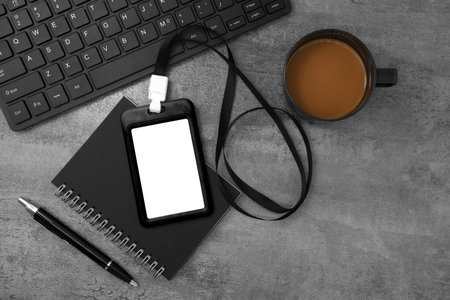 Black plastic badge with keyboard and coffee on stone texture background. Template designed for...