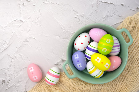 Colorful easter eggs in bowl on stone texture background. Painted eggs. Egg Holiday