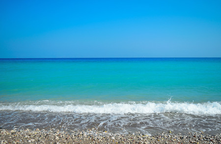 Wave with foam rising sand. Aegean seaの写真素材