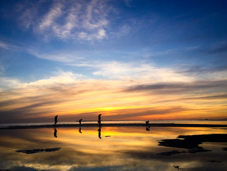 Family Walking at the Beach During Low Tide Sunset