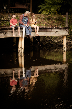 Children Fishing with Great Grandfather on Dockの写真素材