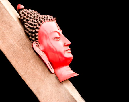 A head shot of Buddha on the wood isolated on the black background.の写真素材
