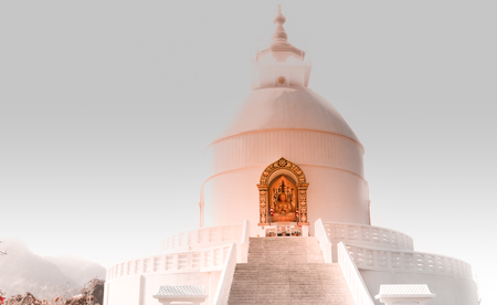 The view of world peace stupa on a foggy day with a bit sun rays on the statue of buddha.の写真素材