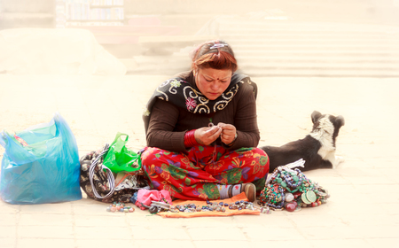 A woman who sales souvenirs in Bhaktapur,Nepal is at work with his dog in the foggy morning.のeditorial素材