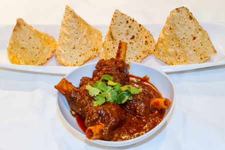 Rajasthani Style mutton curry and dried stylish papad on the Table.の写真素材