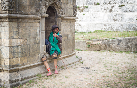 Kathmandu,Nepal - March 2,2016: A disabled needy perosn is showing his hand towards the Photographer while photographing him at the Temple of Pashupatinath.のeditorial素材