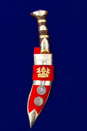Nepali Khukuri or knife with cover on a blue background.