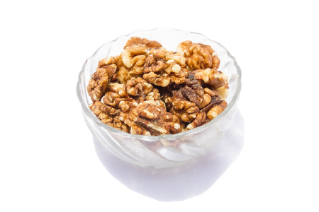 Walnuts in the glass bowl isolated on the white background.の写真素材