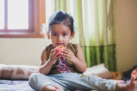 Aisan Cute Happy Child Eating an organic Red Appleの写真素材