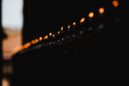 Beautiful Natural Oil Lamps Burning in the Temple,Burning Bokeh Lights against black backgroundsの写真素材
