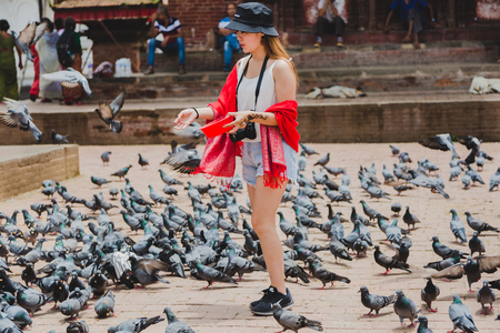 Kathmandu,Nepal - Jul 22,2018:Beautiful Tourist or Foreigner girl  feeding pigeons at kathmandu Durbar Square in Kathmandu, Nepalのeditorial素材