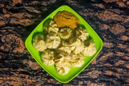 Home made traditional dumpling momos food of Nepal served on a plate with special Momo Sauce. Selective focusの写真素材