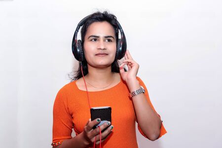 Pretty Asian girl listening music with her headphones in Smart Phone.Mobileの写真素材