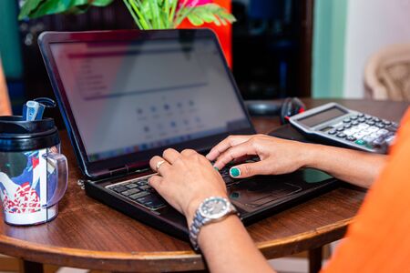 Asian Freelance woman working from home in lockdown time of Covid19. Close up hand with laptop.