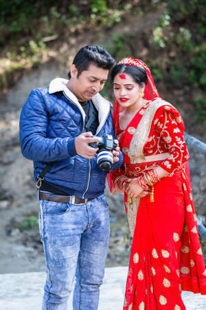 Kathmandu,Nepal - January 29,2020 : Beautiful Nepali bride watching her photos in camera with photographer in outdoor wedding photoshoot. Hindu Wedding photosのeditorial素材