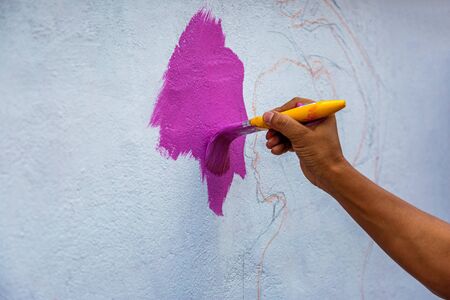 woman Hand painting a wall with brush,Painting Street wall with Artの写真素材