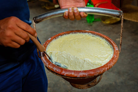 Close up of Plain Curd in a clay pot with holding hands. Dahi or Yogurt