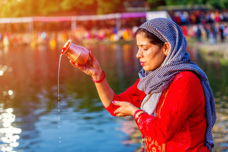 Kathmandu,Nepal - November 1,2019: Hindu devotee offering prayers to sun god standing in water according to hindu rituals during Chhath Puja Festival in Kathmandu. Chath Puja ritualsのeditorial素材