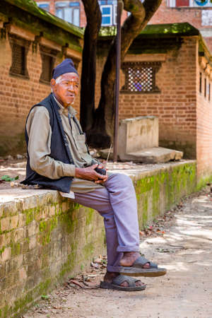 Kathmandu,Nepal - August 2,2019: Nepali old Man Listening to Radio in the village of Nepal.のeditorial素材