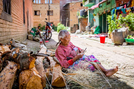 Kathmandu,Nepal - August 2,2019: Old Nepali Woman busy at her work in bhaktapur Nepal.のeditorial素材