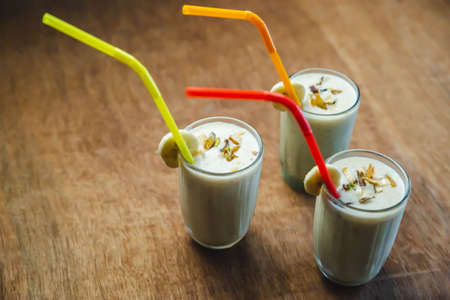 Delicious Banana Milkshakes with Nuts and straws on the table. cold summer drinks,Lassiの写真素材