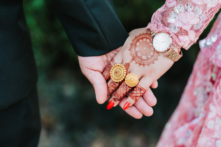 A close up view on the holding hands of a newly married bride and groom from the Hindu Wedding,...