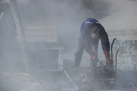 Hakone, Japan - April 9, 2015: Unidentified man is boiling black eggs believed to help extend 7 years of life if eating one at Owakudani, a volcanic valley with active sulphur vents and hot springs.のeditorial素材