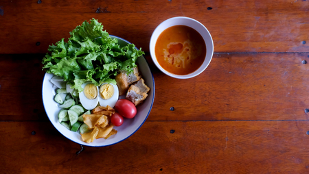 Muslim salad with sauce on wood table and have some space for write wording, delicious appetizer with many kinds of vegetable, green leaf lettuce, onion, boiled egg, tofu, high nutritionの写真素材