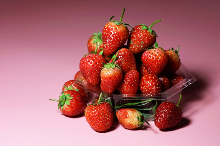 Strawberry on sweet pink background and have space for write wording, sweet romantic fruit for special person, lovers in Valentine day, make many dessert menu or juice or dairy strawberry flavorの写真素材