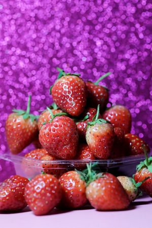 Strawberry on glitter violet background and have space for write wording, sweet romantic fruit for special person, lovers in Valentine day, make many dessert menu or juice or dairy strawberry flavorの写真素材