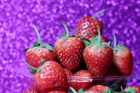 Strawberry on glitter violet background and have space for write wording, sweet romantic fruit for special person, lovers in Valentine day, make many dessert menu or juice or dairy strawberry flavorの写真素材