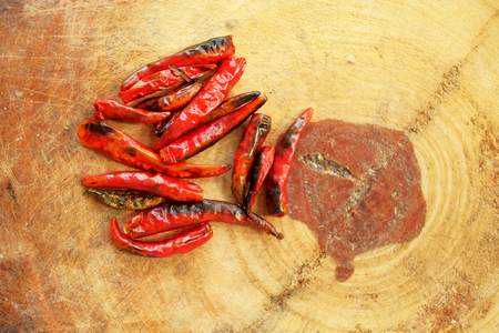Flat lay of dry chili on wood cutting board, main ingredient of making Thai spice food by blending and mixed with others herb and put in curry for spice taste and good smell, have space for write wordingの写真素材