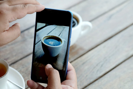 Taking coffee photo by smartphone camera, trendy lifestyle new generation to take and share to...