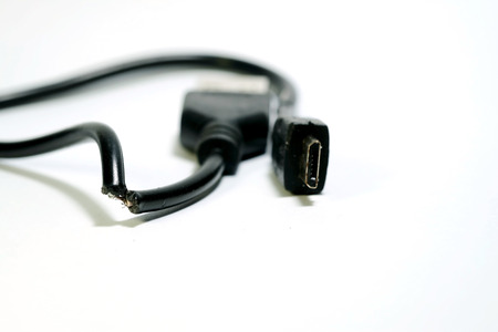 Isolate photo of damage USB cable on white background and space for write wording, consumable or connecting gadget using with smartphone or tablet, high risk of accident, burning and device qualityの写真素材