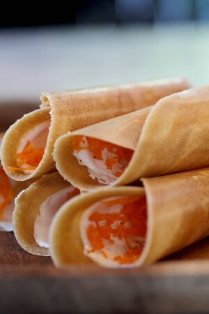 Thai crispy pancake on wood plate with space for write wording , popular sweet street snack sold in market and restaurant, unhealthy food contain high sugar, fat and fat cause of many chronic diseasesの写真素材