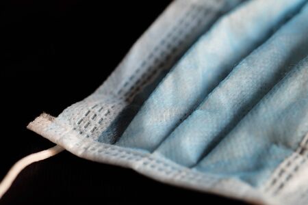 Isolated of blue infection preventive face mask on black background and space for write wording. Important tools for protecting ourselves from infection in Corona virus crisis 2020 and air pollutionの写真素材