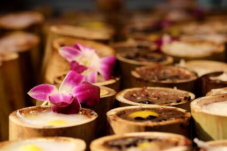 Sweet sticky rice in bamboo with decorated orchid on top. Street food is unique dining lifestyle in Bangkok, Thailand, Unhealthy from dust and dirtiness cause illness such as diarrhea.の写真素材