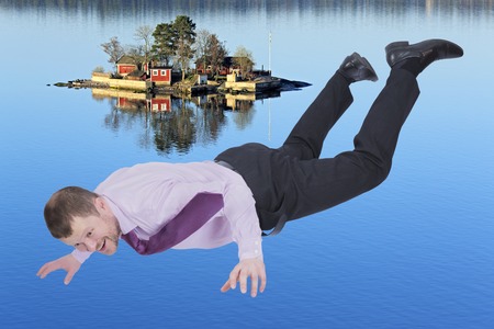 Businessman falling down and sea island in backgroundの写真素材