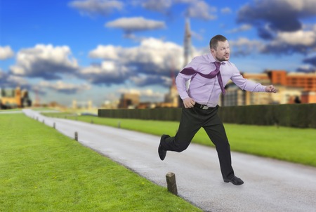 Running businessman in a hurry with modern city in backgroundの写真素材