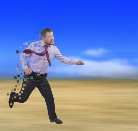 Running businessman in a hurry on blurred backgroundの写真素材