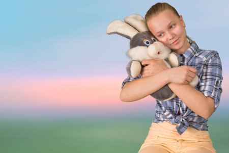 Teen girl embracing the plush toy hare