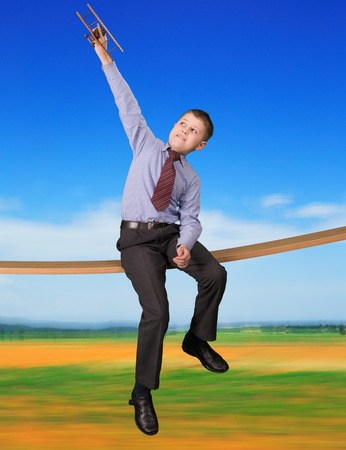 boy in a suit playing with plane modelの写真素材