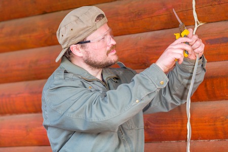 Electrician making an electrical wiring in wooden houseの写真素材