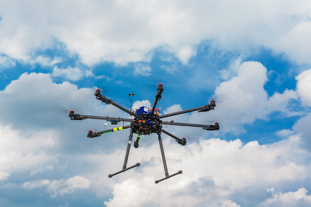 Multicopter in flight on sky and clouds backgroundの写真素材