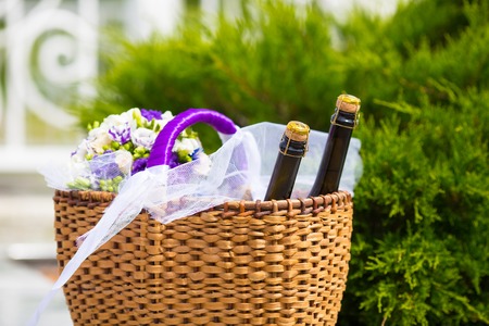 Wicker basket with two bottles champaign and flowersの写真素材