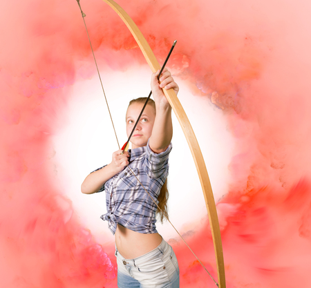 Teen girl practicing archery pink cloud backgroundの写真素材
