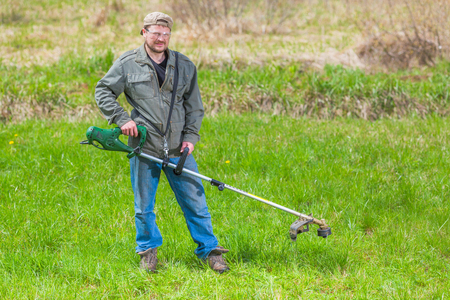 Lawnmower man green field cultivating rural countryの写真素材